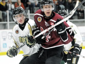 Chatham Maroons' Trevor Richardson, right, fights for position with St. Thomas Stars' Matt Simsons in the first period Sunday at Chatham Memorial Arena.