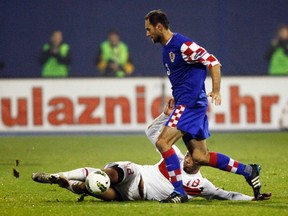 Kazim Kazim (bottom) of Turkey challenges Josip Simunic of Croatia during their Euro 2012 playoff soccer match at Maksimir stadium in Zagreb November 15, 2011.  (REUTERS)