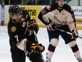 Sarnia Sting defenceman Anthony DeAngelo, left, rips a slap shot while Saginaw Spirit forward Brandon Lindberg looks on Thursday, March 14, 2013 at the RBC Centre in Sarnia, Ont. (QMI Agency file photo)