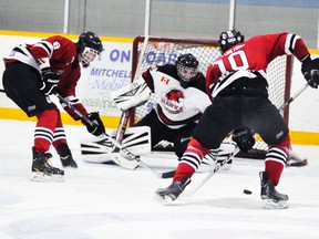 Brent Rae (10) and Will Marcy (8) of the Mitchell Hawks find themselves in glorious scoring opportunity against Walkerton Hawks’ goalie Trevor Fleming Sunday during Western Jr. C hockey league action. Mitchell would build a 3-1 second period lead on the first-place Hawks only to lose, 5-3. ANDY BADER/MITCHELL ADVOCATE