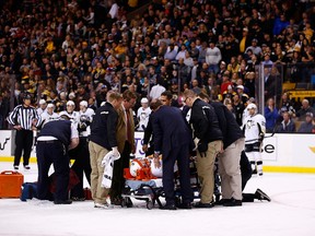 Brooks Orpik of the Pittsburgh Penguins is carted off of the ice on a stretcher by the medical staff in the first period after an altercation with Shawn Thornton of the Boston Bruins during the game at TD Garden on December 7, 2013 in Boston, Massachusetts. (Jared Wickerham/Getty Images/AFP)