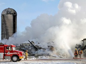 Firefighters put some water on a smoky barn fire just north of Mitchell last Monday morning, Dec. 16. The 100-year-old building and some livestock inside were destroyed in the blaze, which kept firefighters from several area departments busy for hours. MIKE BEITZ/QMI AGENCY