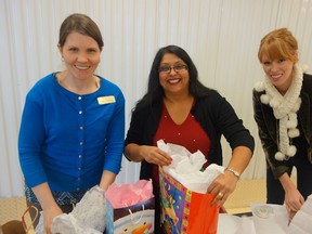 Be a Santa to a Senior elves Robyn Macdonald of the Good Companions Centre Seniors' Centre (left), Soraya Allibhai of the South East Ottawa Community Health Centre (centre) and Kristina Voth-Childs of Hospice Care Ottawa pack gifts for elders in need Monday. Megan Gillis/Ottawa Sun