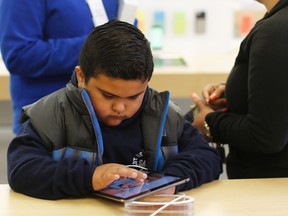 A child uses an iPad Air tablet at the Apple store in San Francisco, Nov. 1, 2013. REUTERS/Stephen Lam