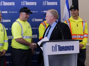 Mayor Rob Ford shakes hands with GFL garbage workers at a press conference about contracting out the east side of Toronto at City Hall on Monday December 16, 2013. (Michael Peake/Toronto Sun)