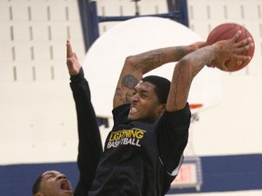 Maurice Bolden slam dunks over Darin Mency while scrimmage during London Lightning practice in London, Ont. on Monday December 16, 2013. (DEREK RUTTAN, The London Free Press)