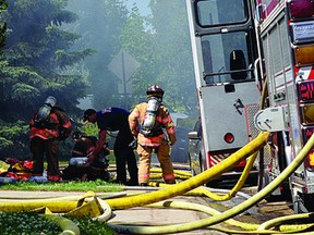 Firefighters at the scene of a house fire on Beauvista Drive in Sherwood Park, Alta. on Wednesday, July 17, 2013. No injuries were reported. (Michael Di Massa/Sherwood Park News/QMI Agency)