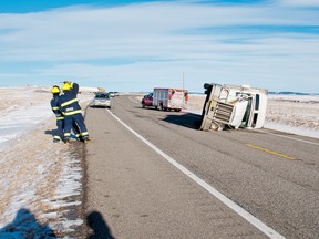 Firefighters had a hard time remaining on their feet while tending to several trucks that rolled over on Highway 22 about 10 kilometres north of Highway 3 on Sunday, Dec. 14. Nearby wind speed readings put the peak gusts at nearly 160 kilometres per hour, well within category two hurricane wind speeds. Bryan Passifiume photo/QMI Agency
