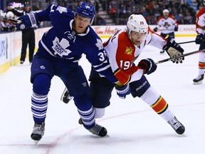Carl Gunnarsson of the Toronto Maple Leafs battles for the puck with Scottie Upshall of the Florida Panthers during NHL Hockey action at the Air Canada Centre in Toronto on Tuesday December 17, 2013. (Dave Abel/Toronto Sun)