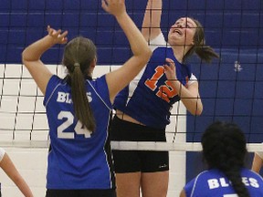 Allie Zohorsky (12) of the Bayridge Blazers spikes the ball while Mackenzie Broughton (24) and Brinda Patel (7) defend for the Kingston Blues in Kingston Area Secondary Schools Athletic Association senior girls volleyball play at Bayridge on Tuesday. Bayridge won the match 3-2. (Tim Gordanier/The Whig-Standard)