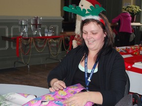 Laura Cudmore, an employee at the Starwood Hotels and Resorts call centre in St. Thomas, wraps a present Tuesday at the Canada Southern Railway Station. Gift wrapping was offered for a fee at the event, which was a fundraiser for the family of Starwood employee Patrick Harmon, who died after a vehicle collision in November. All proceeds from Tuesday's event went to a trust fund for Harmon's two young sons.