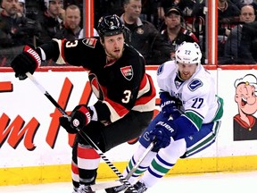 Ottawa Senators' Marc Methot is pursued by Vancouver Canucks' Daniel Sedin as goaltender Robin Lehner looks on during NHL action in Ottawa, Ont. on Thursday November 28, 2013. Errol McGihon/Ottawa Sun/QMI Agency