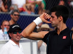 Novak Djokovic gestures as he impersonates Rafael Nadal during their exhibition match in Buenos Aires November 24, 2013. (REUTERS/Marcos Brindicci)