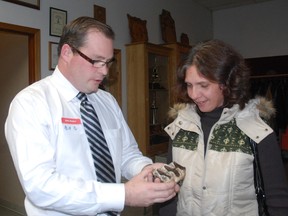 Bill Denning, of the West Elgn chamber of Commerce shows Heather Baker, president of the Dutton and District Chamber of Commerce, a mastodon artifact discovered in Rodney in 1947.