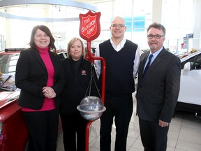 Kingston Whig-Standard's publisher and ad director Liza Nelson (left) and managing editor Mike Beaudin (right) with Bonita McCourt of the Salvation Army and Jason Taylor of the Taylor Auto Mall at the dealership with their Salvation Army Christmas Kettle.
Ian MacAlpine The Whig-Standard