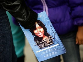 A mourner holds an obituary displaying a picture of shooting victim Renisha McBride during her funeral service in Detroit, Michigan in this file photo taken November 8, 2013. (REUTERS/Joshua Lott/Files)
