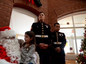 Tori Carbone, 7, chats with Santa Claus at Ronald McDonald House on Thursday. The kids at the house got early Christmas presents courtesy of the United States Marines' Toys for Tots campaign. (Chris Hofley/Ottawa Sun)