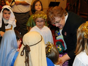 Donna Acre of the Salvation Army accepts mittens, scarves and hats gathered at the St. Paul's United Church Sunday School mitten tree from members of the Sunday school class. The presentation took place after the church's Christmas pageant. Contributed Photo Courtesy of Jeff Helsdon