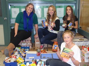 Ms. Tonya Kisilak, Victoria Kyriakopoulos, Tori Cole and Denika Waite help display the 1,566-pound pile of food collected during the Annandale Food Drive. It was donated to the Helping Hand Food Bank. Contributed Photo