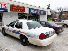 Police continue to work at the scene at a convenience store near 107 Avenue and 104 Street after a fatal stabbing, in Edmonton, Alta., on Wednesday Dec. 18, 2013. David Bloom/Edmonton Sun