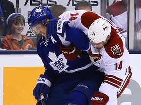 Jay McClement of the Toronto Maple Leafs gets held up by Jeff Halpern of the Phoenix Coyotes during NHL action at the Air Canada Centre on December 19, 2013. (Dave Abel/Toronto Sun/QMI Agency)