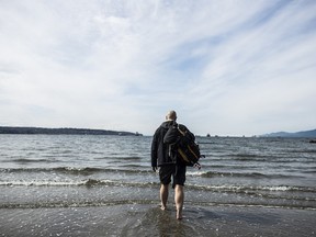 Thane Burnett dips his feet into English Bay to close off his Retro Canada trip in Vancouver, Wednesday, March 27, 2013, CARMINE MARINELLI/QMI AGENCY