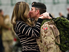 Master Warrant Officer Don Cormier, right, is greeted enthusiastically by his wife, Jennifer Cormier, at the Lecture Training Facility at CFB Edmonton in Edmonton, Alta.,  Dec. 13, 2013. (Codie McLachlan/QMI Agency)