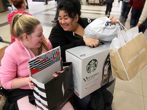 Brianna Nicholas (left) and her mother Barb Erstelle share a laugh while sitting with their Christmas purchases in Polo Park in Winnipeg, Man. Sunday December 22, 2013. (Brian Donogh/Winnipeg Sun)