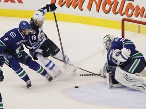 Vancouver Canucks’ goalie Eddie Lack (right) blocks a shot from Winnipeg Jets ' Bryan Little (centre) during the third period of NHL hockey at Rogers Arena in Vancouver, B.C. on Sunday December 22, 2013. Carmine Marinelli/Vancouver 24hours/QMI Agency