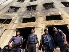 Police officers gather in front of the burnt building of garment factory Tazreen Fashions in Savar November 28, 2012. REUTERS/Andrew Biraj