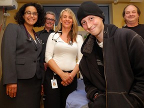 Josh Lynn, 20, of Carrying Place, Ont. sits in an observation room of the emergency department at Belleville General Hospital where doctors and staff saved his life Oct. 3. With him from left are Dr. Mariam Harrison, respiratory therapist Grant Emon, registered nurse Julie Jones-Lentini and Josh’s father, Glen Lynn. - LUKE HENDRY/The Intelligencer