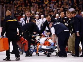 Brooks Orpik of the Pittsburgh Penguins is carted off of the ice on a stretcher by the medical staff in the first period after an altercation with Shawn Thornton at TD Garden on December 7, 2013 in Boston, Massachusetts.  (Jared Wickerham/Getty Images/AFP)
