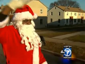 A man dressed as Santa Claus is seen waving in this screengrab of a Washington, D.C., news clip moments before he was shot with a pellet gun. (WJLA ABC-7/YouTube screengrab)