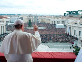 Pope Francis waves as he delivers his first "Urbi et Orbi" (to the city and world) message from the balcony overlooking St. Peter's Square at the Vatican Dec. 25, 2013. REUTERS/Osservatore Romano