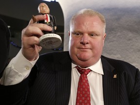 Mayor Rob Ford signs another batch of bobblehead dolls at Toronto City Hall on Friday, December 20, 2013. (Craig Robertson/Toronto Sun)