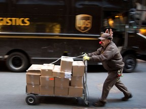 UPS delivery man Vinny Ambrosino prepares to deliver packages on Christmas Eve while wearing a Rudolf nose and antlers in New York, December 24, 2013.  (REUTERS/Carlo Allegri)