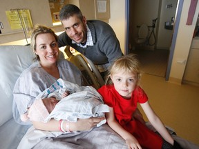 Petawawa, Ont. family Andrea Ainslie, David Wood and five-year-old daughter Ainslie pose with their newborn daughter and sister Ella, a few hours after Andrea gave birth to the first Christmas baby out of three born at Belleville General Hospital on Christmas Day Wednesday, Dec. 25, 2013. -   JEROME LESSARD/The Intelligencer/QMI Agency
