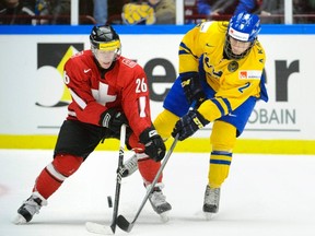 Switzerland's Jason Fuch (left) and Sweden's Anton Karlsson (right) battle for the puck during their game at the World Junior Hockey Championships in Malmo, Sweden on Thursday, Dec. 26, 2013. (Reuters/Ludvig Thunman/TT News Agency)