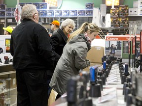 Kristin Corneilie looks at cameras as she shops with her parents, Darlene and Randy Corneillie, for Boxing Day deals at Future Shop on Wellington Road on Thursday. (CRAIG GLOVER, The London Free Press)
