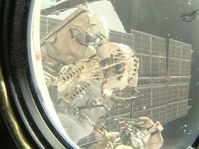A camera inside the International Space Station captured this view of spacewalkers Oleg Kotov (upper left) and Sergey Ryazanskiy (lower right). (NASA TV/HO)