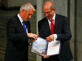 Nobel Peace Prize committee head Thorbjoern Jagland (L) hands over to Ahmet Uzumcu, director general of the Organisation for the Prohibition of Chemical Weapons (OPCW), the medal and the diploma during the Nobel Peace Prize awards ceremony at the City Hall in Oslo Dec. 10, 2013.     
REUTERS/Tobias Schwarz