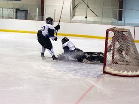 Down and out, Coaldale's goaltender sprawls helplessly as the puck flies overhead.
