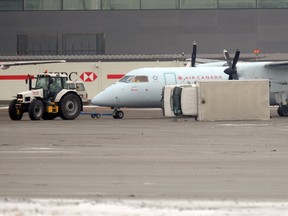 A cube van lays on its side after being hit by an Air Canada plane on the apron at the Calgary International Airport in NE Calgary, Alta. on Monday December 30, 2013. According to reports the driver of the van suffered minor injuries. Stuart Dryden/Calgary Sun