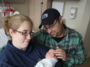 Kristen and Bill Mustard of Westport hold their new daughter Charlotte, the new year's baby at Kingston General Hospital, Thursday morning. 
Elliot Ferguson The Whig-Standard