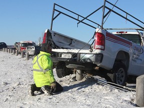 A tow truck operator begins removing one of two vehicles that ended up on the fencing on the bridge on Highway 401 between Highway 15 and Montreal Street Friday morning as a result of a four-vehicle accident. It was one of several accidents on the highway during the morning.
Michael Lea The Whig-Standard