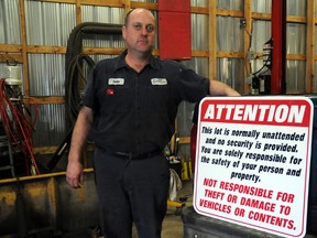 Steve Fritzley holds up a new disclaimer sign for his Huron Road business. Fritzley has been the victim of four separate thefts in the past three years at his automotive repair shop west of Seaforth.