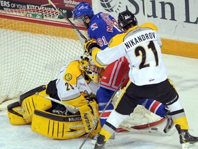 Kitchener Rangers forward Matia Marcantuoni fights for a loose puck with Sarnia Sting defender Deniel Nikandrov as Staing goalie Taylor Dupuis tries to smoother it  in the first period of their game in Kitchener on Friday night. Sarnia dropped the contest 6-5. Photo courtesy of David Bebee, Waterloo Record Staff
