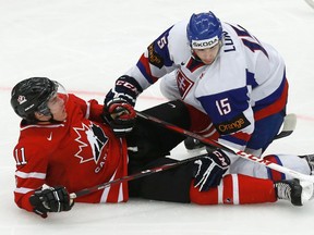 Slovakia's Mario Lunter, right, knocks down Canada's Bo Horvat during the third period of their IIHF World Junior Championship game in Malmo, Sweden, Dec, 30, 2013.
