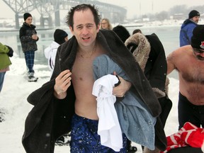 Cory Coulter tries to get warm after plunging into the icy waters under the Bluewater Bridge as part of the Point Edward Casino's Polar Bear Plunge on Sunday, Jan. 5. The event was Coulter's second dip with the group. SHAUN BISSON/THE OBSERVEr/QMI AGENCY