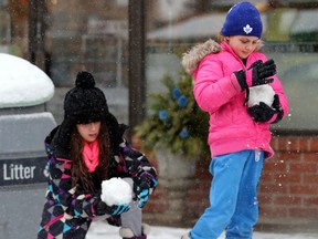 Two girls gather snowballs in north Toronto on Sunday. (MICHAEL PEAKE, Toronto Sun)